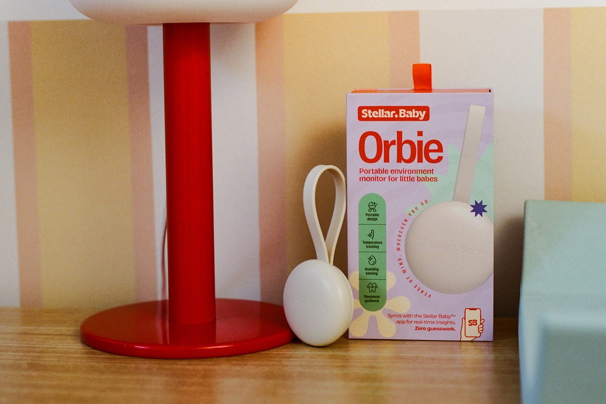 Orbie and its box beside a red lamp in a nursery