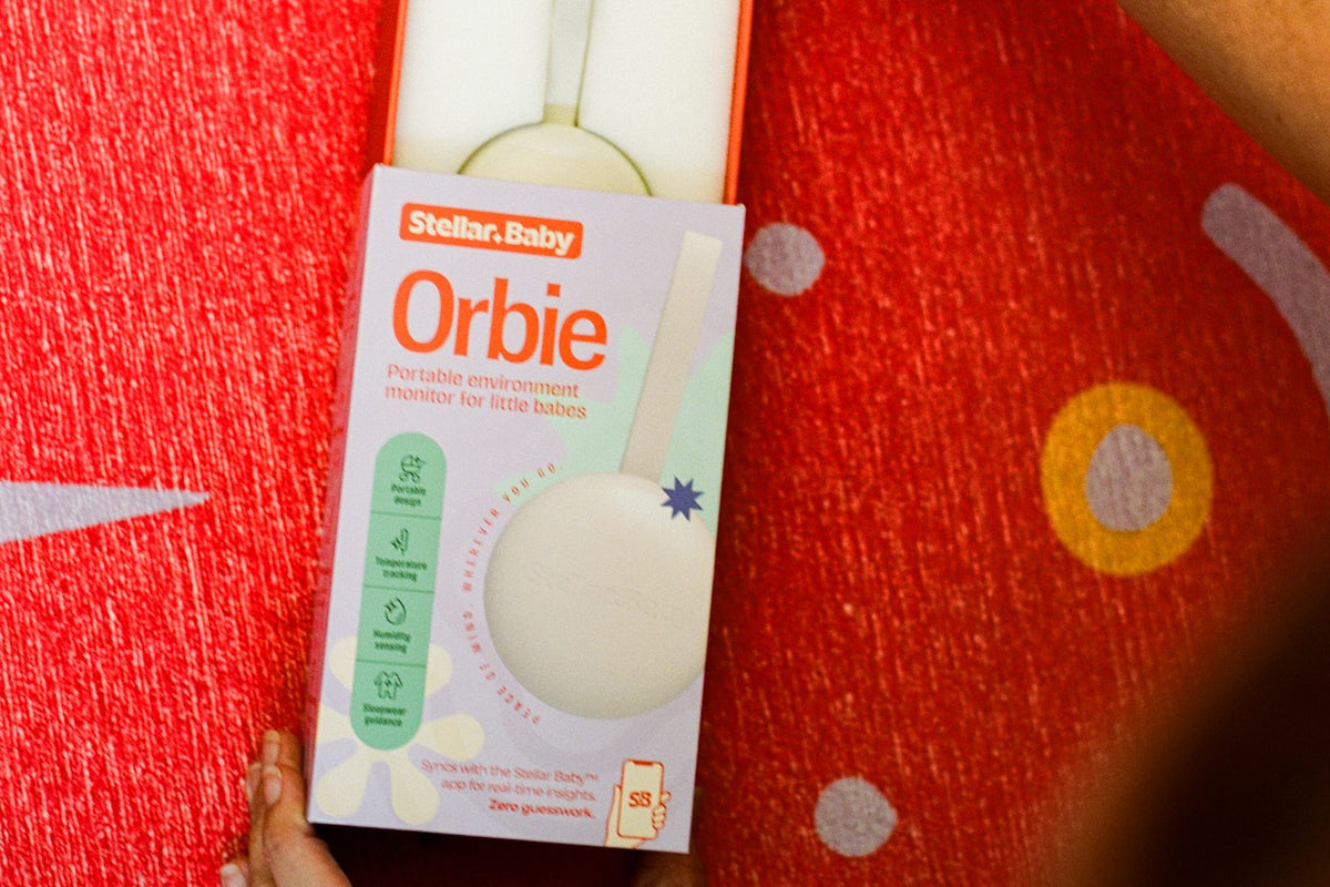 The Orbie box held above a red surface, showing the device inside