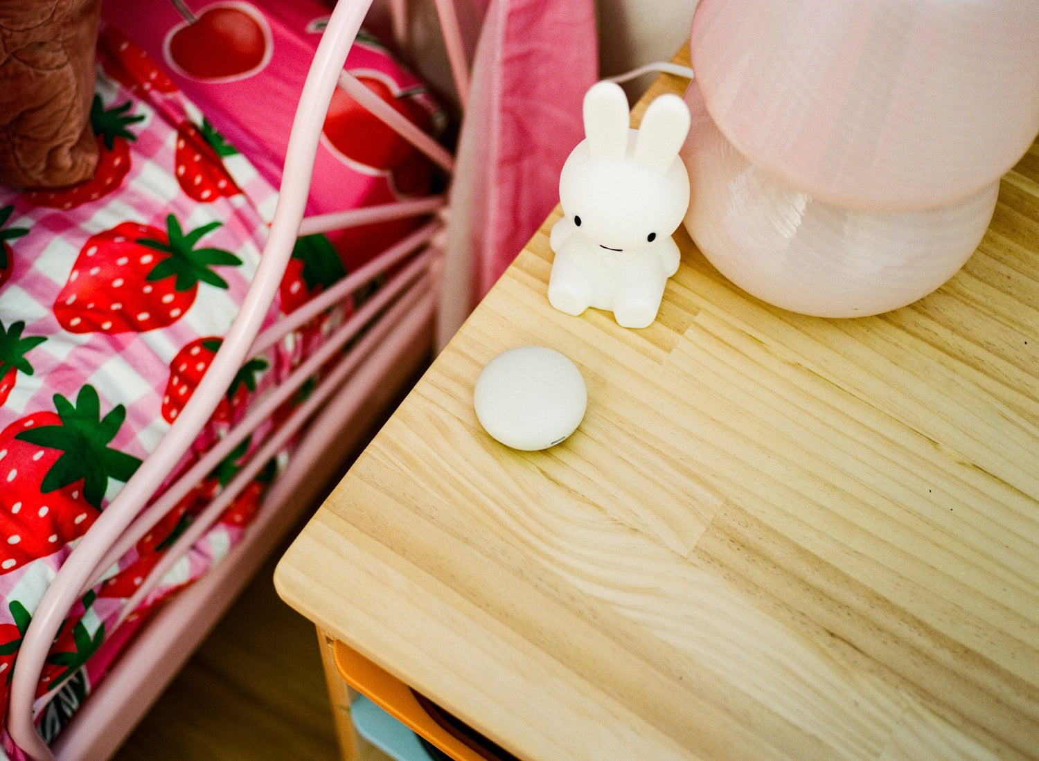 Orbie on a bedside table beside a soft toy