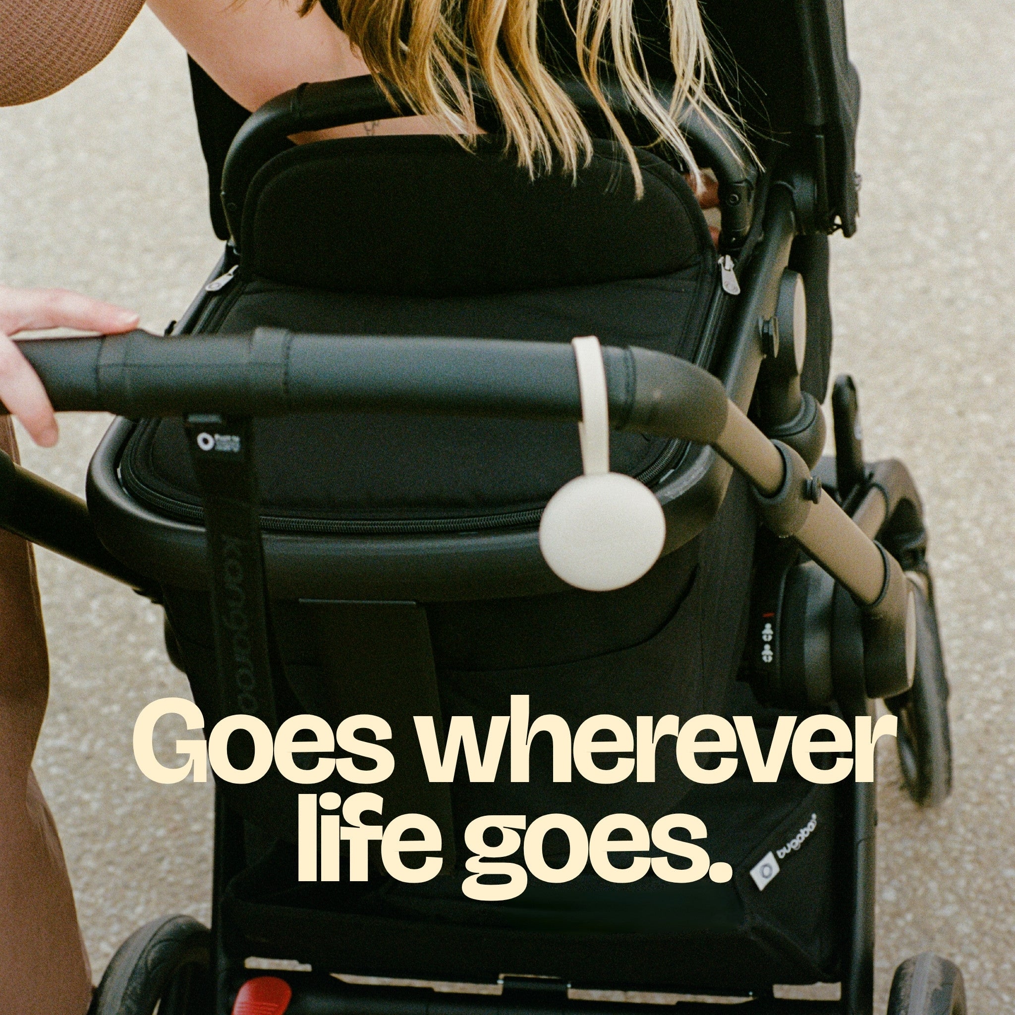 Orbie clipped to a pram handle, out on the go